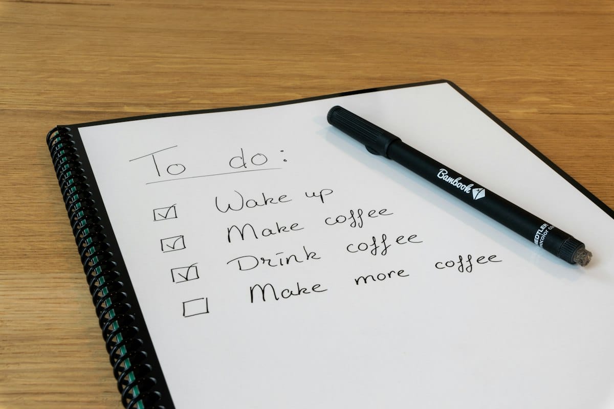 Bloc-notes avec un stylo posé dessus, pour noter les questions à poser avant de lancer une refonte